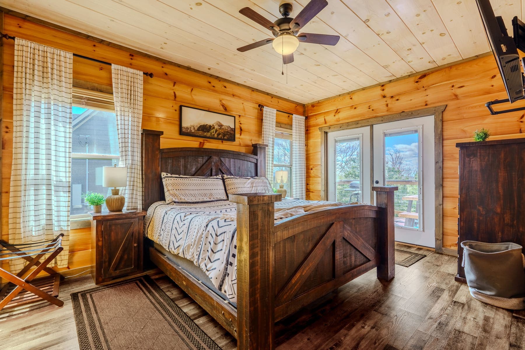 King bedroom with rustic barn-door style bed and patterned bedding
