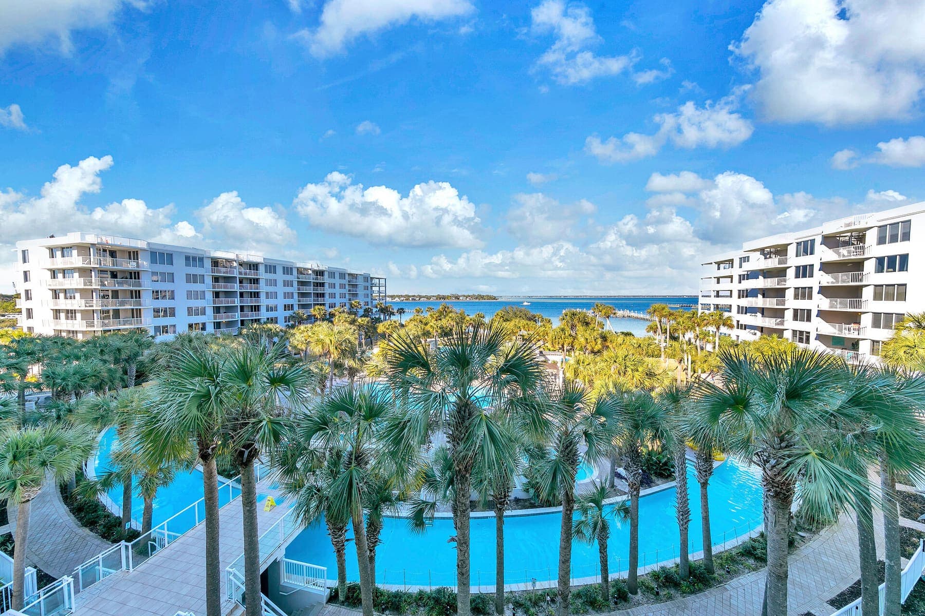 Elevated view of the two condo wings framing the curving lazy river and palm gardens