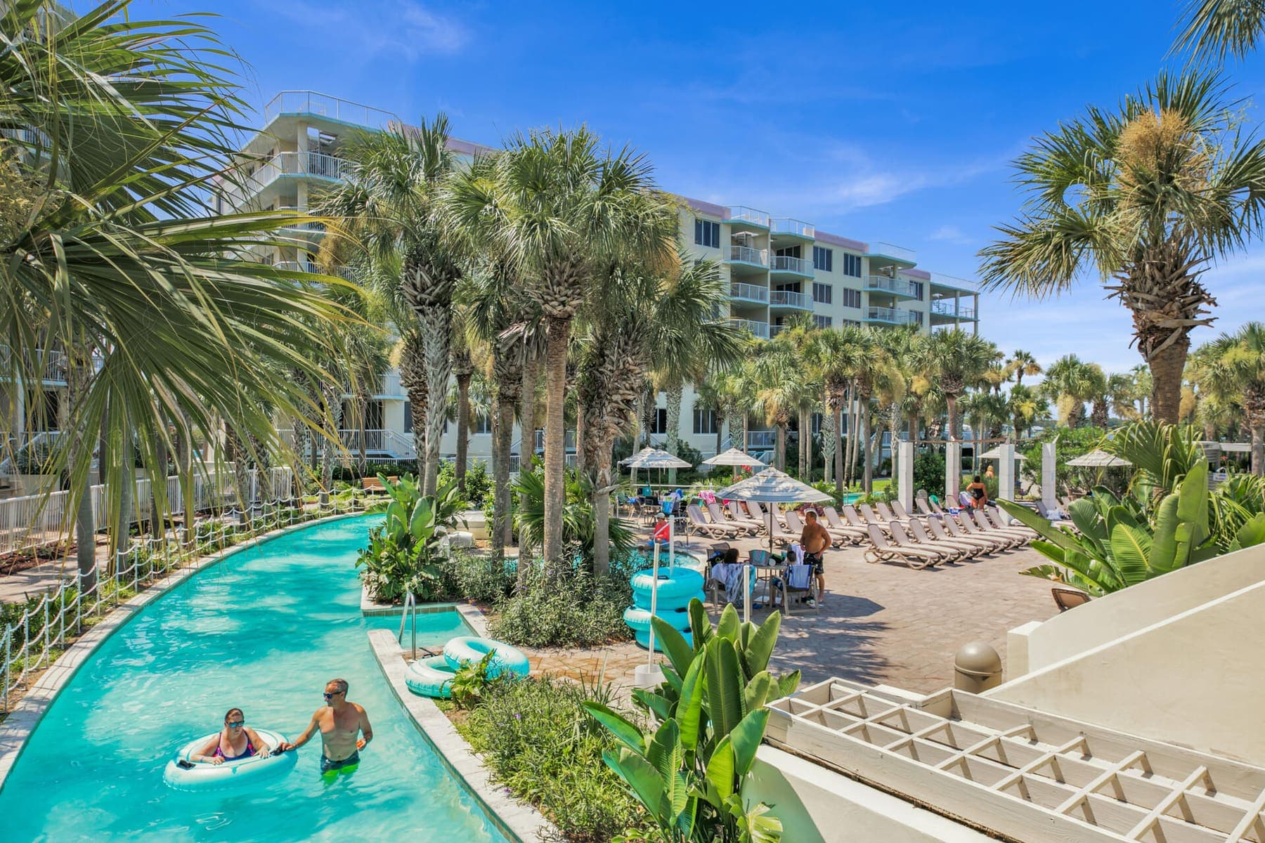 Palm-lined lazy river curving through the resort grounds