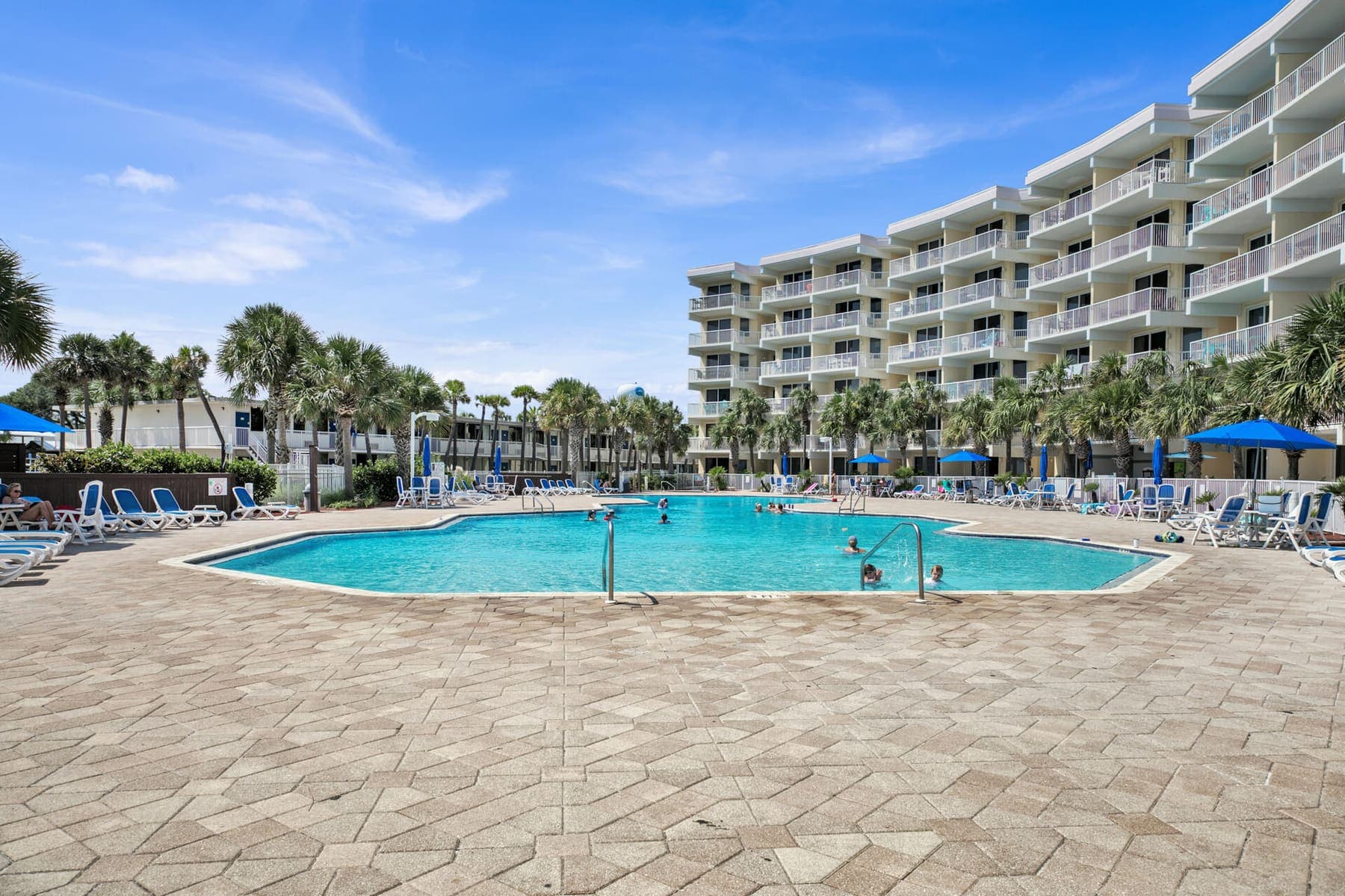 Resort pool with rows of loungers on a bright day
