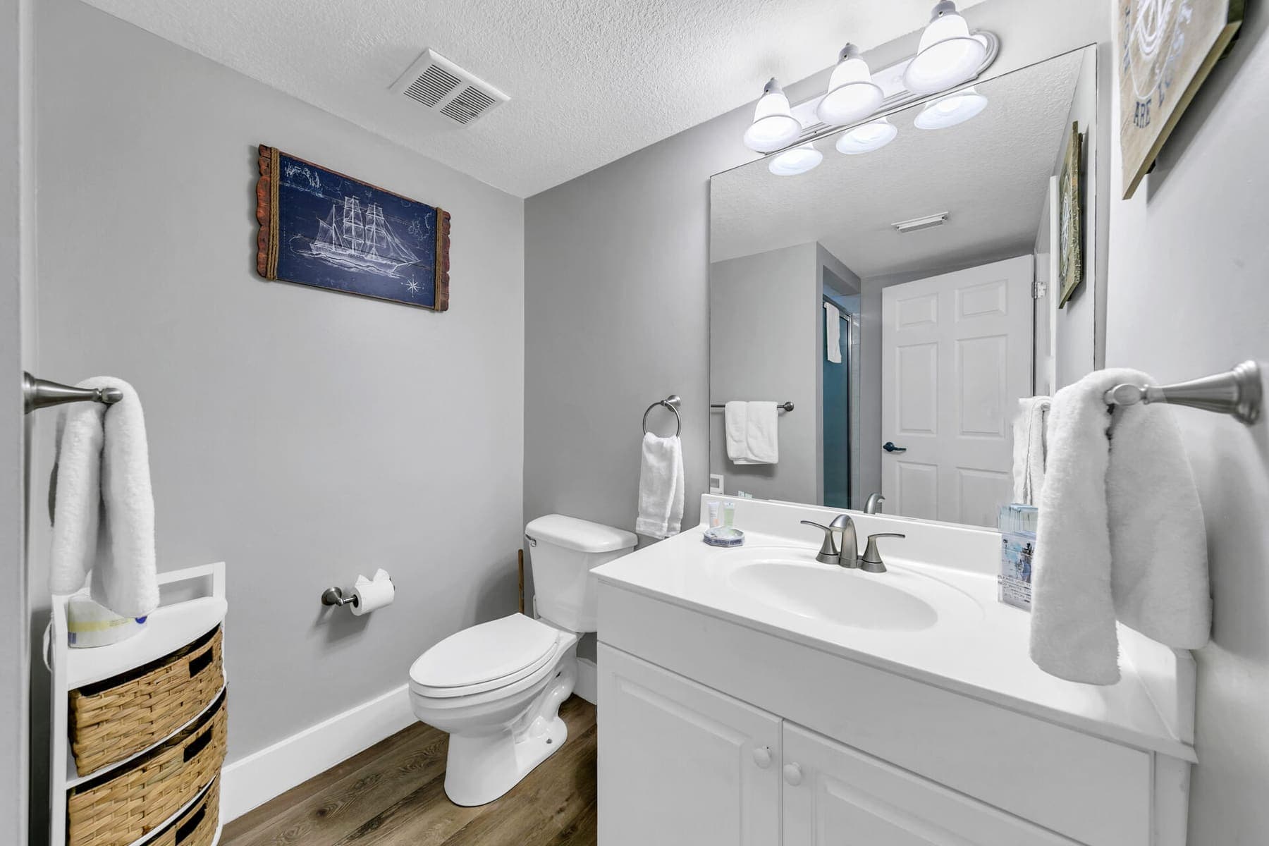 Guest bathroom with white vanity and navy shiplap accent