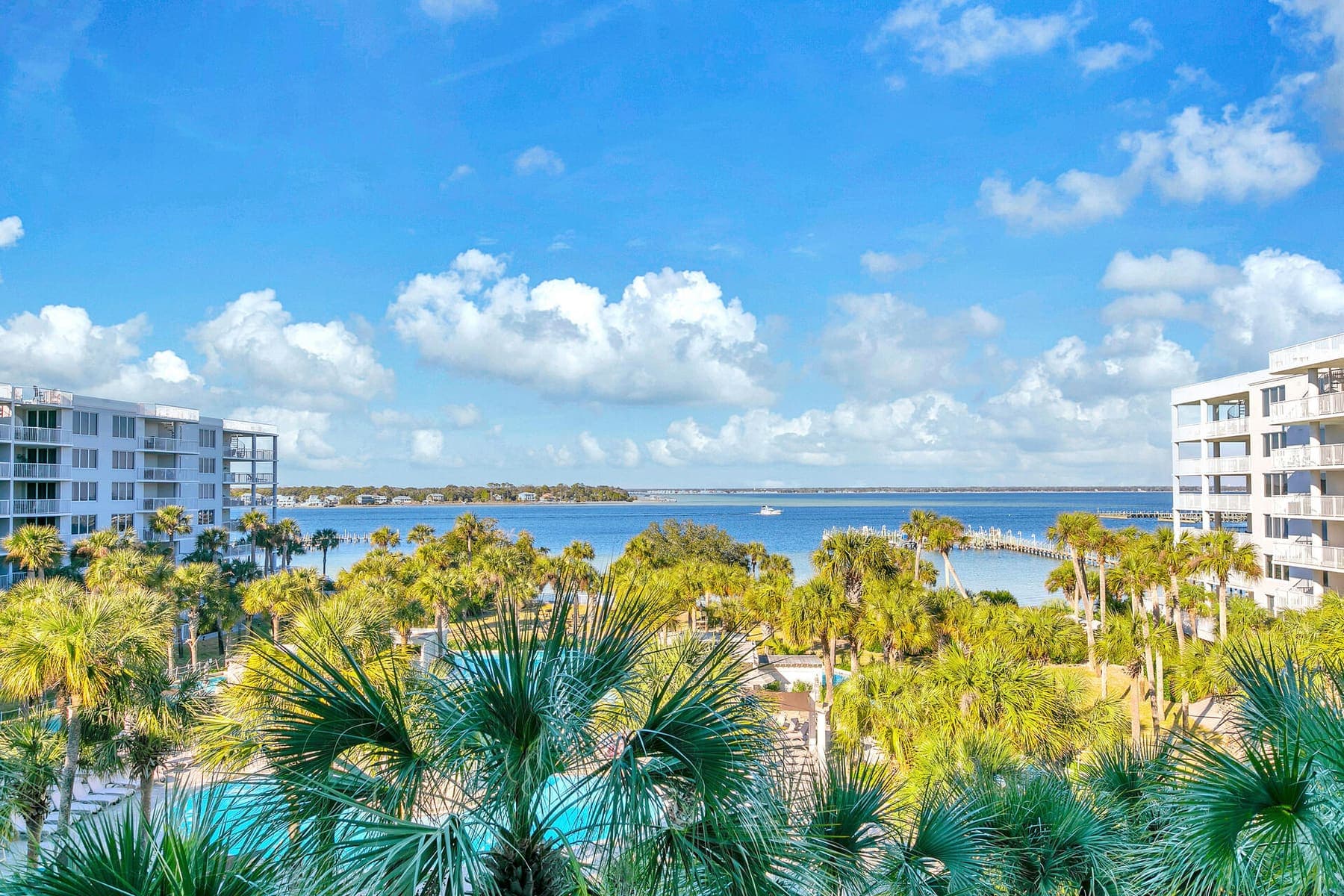 Balcony panorama over the palms and pools to Choctawhatchee Bay and open sky